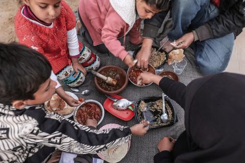 عائلة فلسطينية نازحة تتناول فطورها خلال شهر رمضان داخل خيمة متداعية في مخيم النصيرات للاجئين وسط قطاع غزة. تواجه العائلات النازحة ظروفًا معيشية قاسية نتيجة الحرب، مع انعدام الدخل ونقص حاد في المساعدات الإنسانية، 26 فبراير/شباط 2026. تصوير: معز صالحي