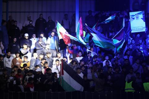 لاعبون فلسطينيون من فريقي النصيرات ورفح يتنافسون خلال مباراة كرة قدم على ملعب نادي خدمات النصيرات، ضمن بطولة غزة الرمضانية، بحضور حشد جماهيري كبير، في مخيم النصيرات بوسط قطاع غزة، بتاريخ 21 فبراير/شباط 2026. تصوير: معز صالحي / apaimages