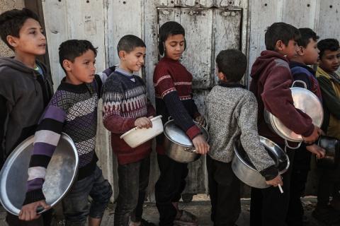 تجمعت عائلات فلسطينية نازحة لتلقي وجبات مجانية من مطبخ خيري في مخيم النصيرات للاجئين، وسط تعليق عمليات منظمة