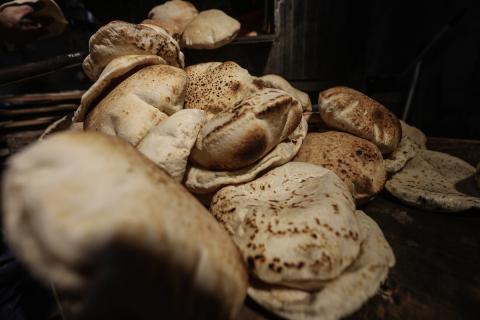 نساء فلسطينيات، زوجات شهداء الحرب، يُجهّزن الخبز لتوزيعه على العائلات النازحة والمحتاجة في مخيم البريج للاجئين وسط قطاع غزة خلال شهر رمضان، في مشهد يُجسّد روح التضامن والصمود في ظلّ الظروف الإنسانية الصعبة، فبراير/شباط 2026. تصوير: معز صالحي