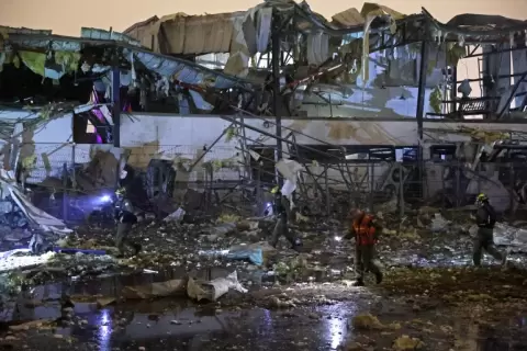 فرق الطوارئ تعاين الدمار بعد سقوط صاروخ باليستي إيراني في منطقة صناعية بمدينة بتاح تكفا (الفرنسية).webp