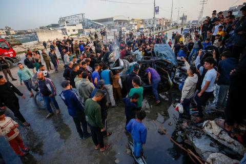 يتفقد فلسطينيون آثار غارة جوية إسرائيلية استهدفت مركبة في شارع صلاح الدين قرب مدخل مخيم المغازي للاجئين وسط قطاع غزة، في 4 أبريل/نيسان 2026 (صورة: أحمد إبراهيم)