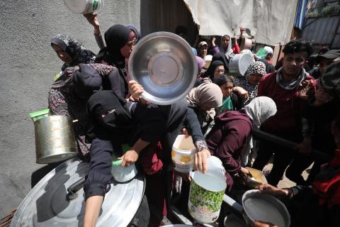 إحدى الجمعيات الخيرية توزع وجبات طعام على الفلسطينيين النازحين في مخيم النصيرات للاجئين، في ظل استمرار نقص الغذاء نتيجةً للسياسة الإسرائيلية المتعلقة بدخول المساعدات إلى مدينة غزة، في 11 أبريل/نيسان 2026. (تصوير: حسن جيدي)