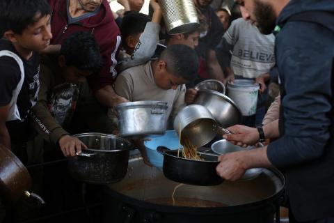 يتلقى فلسطينيون نازحون طعامًا من مطبخ خيري في مخيم النصيرات للاجئين وسط قطاع غزة، في 23 أبريل/نيسان 2026 (صورة: حسن الجديدي)