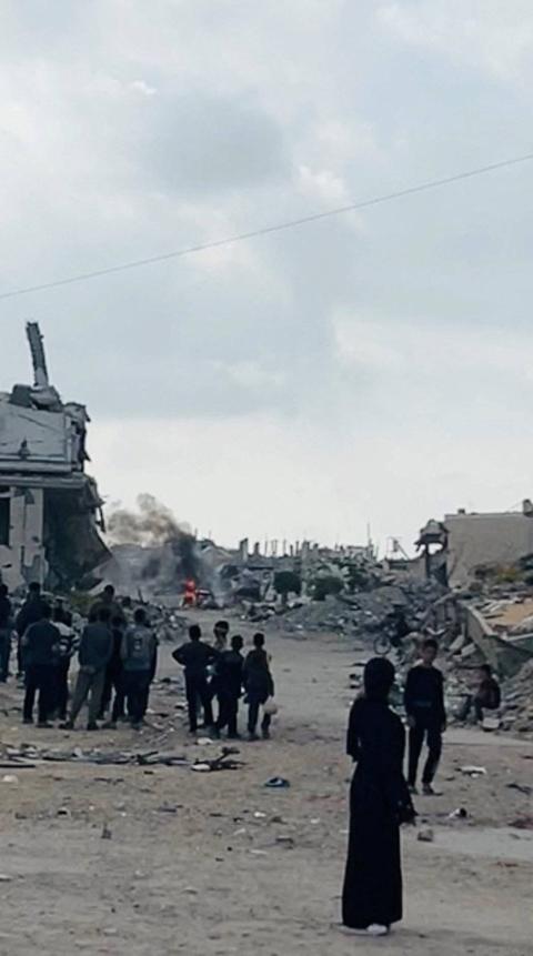 فلسطينيون يتابعون اشتباكات بين مقاتلين من فصائل غزة وميليشيات مدعومة من إسرائيل في خان يونس جنوب القطاع يوم الاثنين (صورة من فيديو بثته رويترز).jpeg