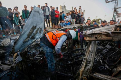 يتفقد فلسطينيون آثار غارة جوية إسرائيلية استهدفت مركبة في شارع صلاح الدين قرب مدخل مخيم المغازي للاجئين وسط قطاع غزة، في 4 أبريل/نيسان 2026.  (صورة: أحمد إبراهيم)