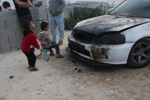 يقف فلسطينيون وسط آثار الدمار في قرية عورتا جنوب نابلس شمال الضفة الغربية، عقب هجوم نفذه مستوطنون إسرائيليون استهدف مركبات ومنازل المواطنين، مخلّفًا أضرارًا واسعة، وفق شهود عيان. 17 أبريل/نيسان 2026. تصوير: محمد ناصر.
