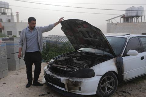 يقف فلسطينيون وسط آثار الدمار في قرية عورتا جنوب نابلس شمال الضفة الغربية، عقب هجوم نفذه مستوطنون إسرائيليون استهدف مركبات ومنازل المواطنين، مخلّفًا أضرارًا واسعة، وفق شهود عيان. 17 أبريل/نيسان 2026. تصوير: محمد ناصر.