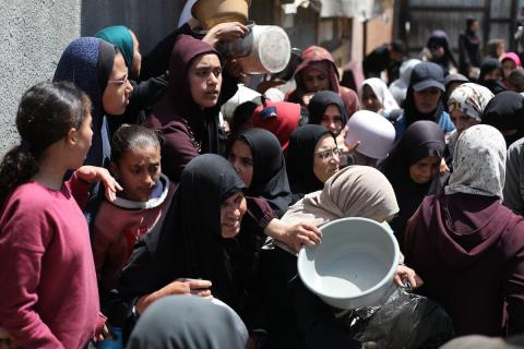 إحدى الجمعيات الخيرية توزع وجبات طعام على الفلسطينيين النازحين في مخيم النصيرات للاجئين، في ظل استمرار نقص الغذاء نتيجةً للسياسة الإسرائيلية المتعلقة بدخول المساعدات إلى مدينة غزة، في 11 أبريل/نيسان 2026. (تصوير: حسن جيدي)
