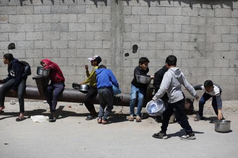 إحدى الجمعيات الخيرية توزع وجبات طعام على الفلسطينيين النازحين في مخيم النصيرات للاجئين، في ظل استمرار نقص الغذاء نتيجةً للسياسة الإسرائيلية المتعلقة بدخول المساعدات إلى قطاع غزة، في 11 أبريل/نيسان 2026. (تصوير: حسن جيدي)