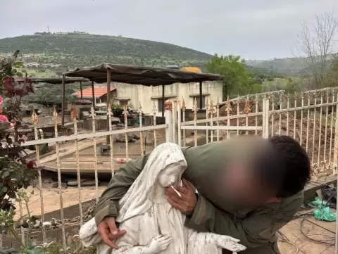 جندي إسرائيلي في جنوب لبنان يلتقط صورة مع تمثال مريم العذراء ويضغ في فمها سيجارة.webp