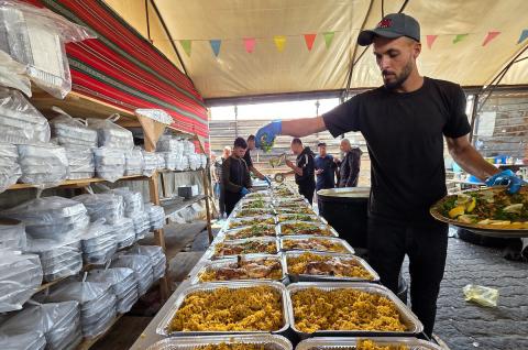 تُظهر الصورة نازحين فلسطينيين متجمعين حول نقطة توزيع طعام في خان يونس جنوب قطاع غزة، حيث ينتظر رجال ونساء وأطفال الحصول على وجبات من مطبخ خيري وسط ظروف إنسانية صعبة،  8 مايو/أيار 2026. عدسة : طارق محمد