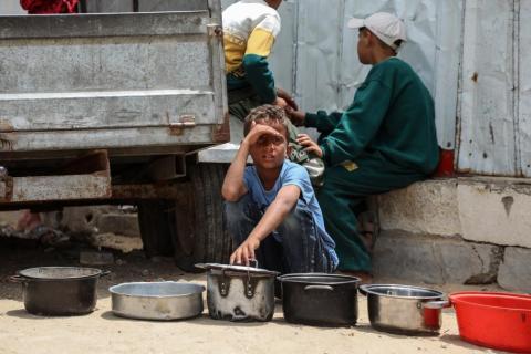 مدينة غزة 18 مايو 2026 (شينخوا) في الصورة الملتقطة يوم 18 مايو 2026، فلسطيني يحمل أواني الطعام وينتظر بالقرب من مطبخ مجتمعي للحصول على طعام مجاني في مدينة غزة..JPG
