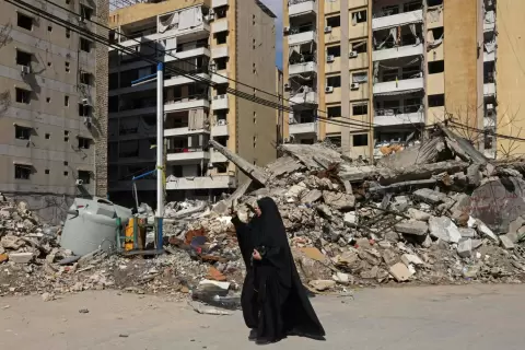 لبنانية توثّق الدمار بالضاحية الجنوبية لبيروت خلال جولة للصحافيين نظّمها «حزب الله» الأربعاء (أ.ف.ب).webp