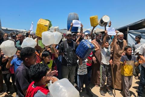 فلسطينيون نازحون يحملون عبوات مياه فارغة خلال احتجاج للمطالبة بتوفير مياه شرب آمنة في خان يونس جنوب قطاع غزة، 25 مايو/أيار 2026. تصوير: طارق محمد