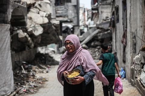 تجمع فلسطينيون نازحون، بينهم نساء وأطفال، لتلقي وجبات طعام من مطبخ خيري في مخيم البريج للاجئين وسط قطاع غزة، في 15 مايو/أيار 2026.(صورة: معز صالحي)