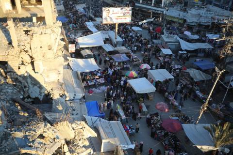 فلسطينيون يتجولون في سوق بمخيم النصيرات للاجئين وسط قطاع غزة، قبيل عيد الأضحى، وسط ضعف في الطلب وتراجع القدرة الشرائية، 25 مايو/أيار 2026. تصوير: حسن الجديدي