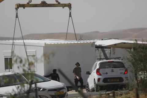مستوطنون إسرائيليون ينصبون وحدات سكنية متنقلة جديدة في بؤرة استيطانية أُنشئت حديثًا على أراضٍ فلسطينية في قرية أم الخير بمسافر يطا، جنوب الخليل، تحت حماية الجيش الإسرائيلي، في 20 أيار/ مايو 2026. تصوير: مأمون وزواز.