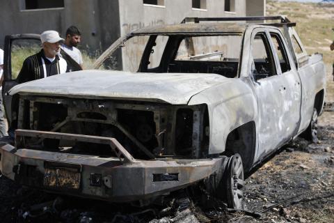 يتفقد فلسطينيون مركبةً تضررت بعد أن أضرم فيها مستوطنون إسرائيليون النار في وادي الرحيم قرب بلدة يطا، جنوب الخليل في الضفة الغربية، في الأول من مايو/أيار 2026.(صورة: مأمون وزواز)