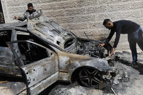 فلسطينيون يتفقدون مركبات وممتلكات أُحرقت وتضررت في هجوم لمستوطنين إسرائيليين خلال الليل في بلدة حلحول، شمال الخليل بالضفة الغربية المحتلة، في 20 أيار/ مايو 2026. تصوير: مأمون وزواز.