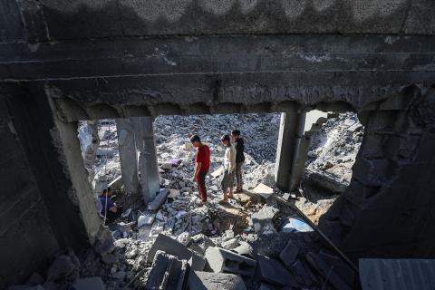 فلسطينيون يتفقدون الأضرار التي لحقت بالمنازل والشوارع عقب غارة إسرائيلية استهدفت منزلاً ومتاجر في مخيم البريج للاجئين وسط قطاع غزة، 23 مايو/أيار 2026. الصورة: معز صالحي