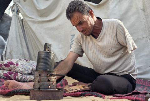 الفلسطيني محمد النواجة، الذي بُترت يده اليسرى في غارة إسرائيلية أثناء فراره من النزوح، يجلس داخل خيمة مهترئة في خان يونس جنوب قطاع غزة، في 18 مايو/أيار 2026، آملاً في الحصول على علاج خارج القطاع وطرف صناعي يساعده على مواصلة حياته. الصورة: طارق محمد
