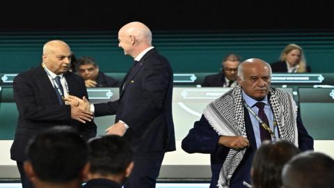 رئيس فيفا جياني إنفانتينو يصافح رئيس الاتحاد الإسرائيلي لكرة القدم موشيه زواريز، بينما يغادر رئيس الاتحاد الفلسطيني جبريل الرجوب المنصة خلال كونغرس فيفا في فانكوفر، 30 نيسان 2026. (رويترز).jpeg