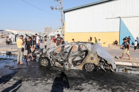 يتفقد فلسطينيون سيارة مدنية مدمرة بعد استهدافها في غارة جوية إسرائيلية على شارع صلاح الدين في منطقة المغازي بوسط قطاع غزة، في 26 يونيو/حزيران 2026. صورة: معز صالحي