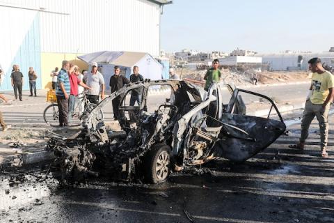 يتفقد فلسطينيون مركبة مدنية مدمرة عقب استهدافها في غارة جوية إسرائيلية على شارع صلاح الدين في منطقة المغازي وسط قطاع غزة، في 26 يونيو/حزيران 2026.عدسة معز صالحي