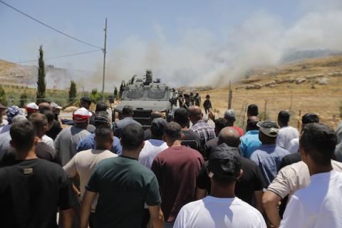 فلسطينيون يتجمعون في قرية إدنا غرب الخليل احتجاجاً على حرق أجزاء من أراضيهم، قبل أن تفرّقهم القوات الإسرائيلية بالغاز والقنابل الصوتية والرصاص الحي. تصوير: مأمون وزواز