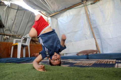 الطفل محمد شعبان (9 سنوات) رغم بتر ساقيه وذراعه يلعب كرة القدم داخل خيمة النزوح في جباليا شمال غزة، 22 يونيو/حزيران 2026.تصوير: بلال أسامة