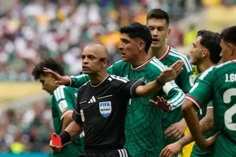 يحتج لاعبو المنتخب المكسيكي لدى الحكم البرازيلي ويلتون سامبايو بعد إشهاره البطاقة الحمراء في وجه المدافع سيزار مونتيس (أ.ب).webp