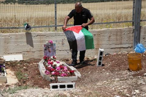 أب فلسطيني يضع باقة زهور على قبر نجله عماد هارون اشتية في قرية سالم قرب نابلس، في 2 يونيو/حزيران 2026. ووفق وزارة الصحة، استشهد اشتية، البالغ من العمر 26 عاماً، برصاص القوات الإسرائيلية قرب جدار الفصل 31 مايو/أيار.تصوير: محمد ناصر