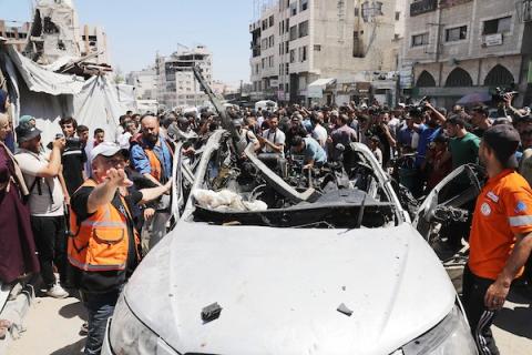 تجمع فلسطينيون وعناصر من الدفاع المدني حول مركبة مدمرة استُهدفت في غارة جوية إسرائيلية على مدينة غزة، في 18 يونيو/حزيران 2026.صورة: بلال أسامة