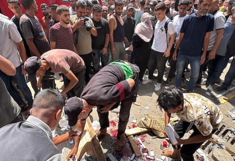 تجمّع فلسطينيون في موقع غارة جوية إسرائيلية قرب مدخل مستشفى شهداء الأقصى في دير البلح، وسط قطاع غزة، بينما كانت فرق الإسعاف تُجلي الجرحى من الموقع، في 25 يوليو/تموز 2026.صورة: أحمد إبراهيم
