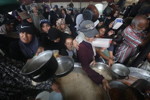 تجمّع فلسطينيون نازحون لتلقّي وجبات طعام من مطبخ خيري وحيد متبقٍ في مخيم النصيرات للاجئين، وسط قطاع غزة، في 23 يوليو/تموز 2026.صورة: حسن الجدي