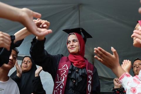 الطالبة دانا سعادة تحتفل مع عائلتها داخل خيمة للنازحين غرب مدينة غزة، بعد حصولها على معدل 96% في الفرع الأدبي بامتحانات التوجيهي، 24 تموز/ يوليو 2026.  تصوير: بلال أسامة