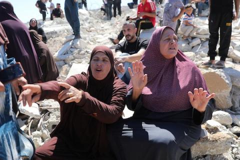 يجلس فلسطينيون على أنقاض منزل هدمته القوات الإسرائيلية في بلدة بيت عوا، جنوب الخليل، بالضفة الغربية ، في 20 يوليو/تموز 2026.صورة: مأمون وزواز