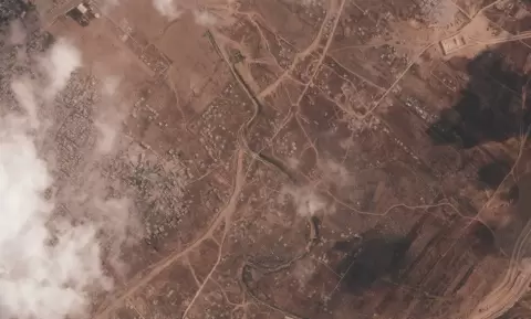 صورة التقطها قمر اصطناعي تُظهر جزءاً من جدار ترابي تُشيّده القوات الإسرائيلية وسط قطاع غزة 7 يوليو 2026 ويظهر مخيم البريج للاجئين على اليسار بينما يقطع وادي غزة الجدار وتقع قاعدة عسكرية إسرائيلية على الجانب الآخر (أ.ب).webp