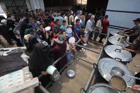 يتجمع فلسطينيون نازحون لتلقي وجبات طعام من مطبخ خيري في مخيم النصيرات للاجئين، وسط قطاع غزة، في 30 يوليو/تموز 2026. صورة: حسن الجدي