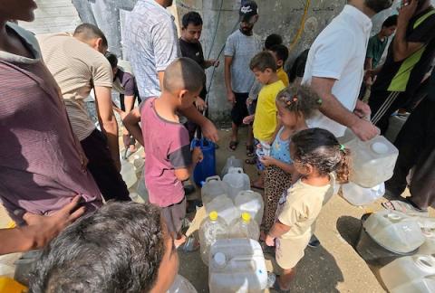 فلسطينيون، بينهم نساء وأطفال، يملؤون حاويات بمياه محلاة في محطة تحلية مياه بخان يونس، جنوب قطاع غزة، في 23 أغسطس/آب 2026.(صورة: طارق محمد)