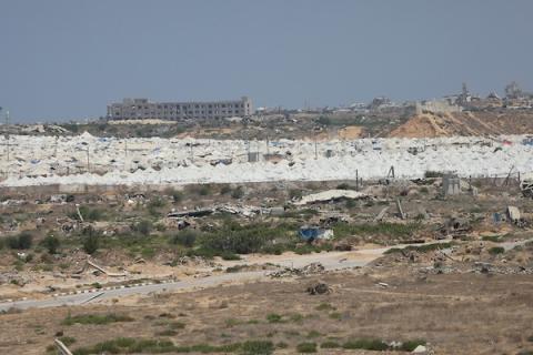 فلسطينيون يتنقلون بين أنقاض مبانٍ مدمرة في منطقة المغاري وسط قطاع غزة، في مشهد يعكس حجم الأضرار التي لحقت بالمناطق السكنية خلال الحرب. (تصوير: حسن الجدي)