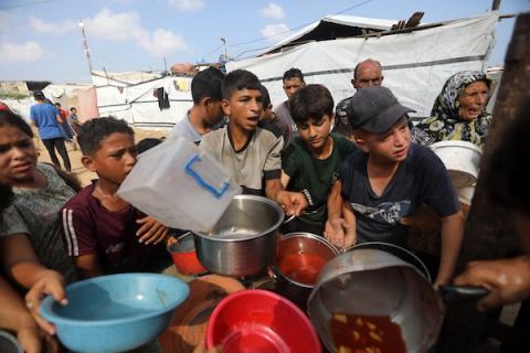 في 22 أغسطس/آب 2026، تلقى فلسطينيون وجبات طعام مطبوخة مجانية في مخيم للنازحين بمنطقة جباليا شمال قطاع غزة. ويأتي هذا التوزيع في ظل ظروف إنسانية صعبة وحاجة ماسة للمساعدات الغذائية في قطاع غزة.  (صورة: بلال أسامة)