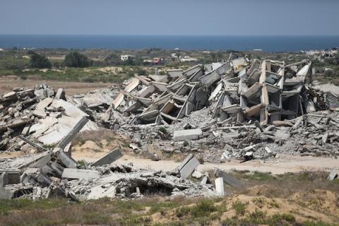 فلسطينيون يتنقلون بين أنقاض مبانٍ مدمرة في منطقة المغاري وسط قطاع غزة، في مشهد يعكس حجم الأضرار التي لحقت بالمناطق السكنية خلال الحرب. (تصوير: حسن الجدي)