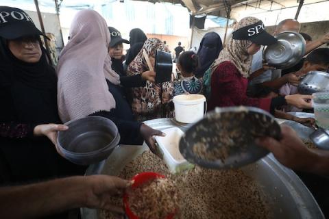 نازحون فلسطينيون يتجمعون لتلقي وجبات طعام من مطبخ خيري في مخيم النصيرات للاجئين، وسط قطاع غزة، في 16 آب/أغسطس 2026. (صورة: حسن الجدي)