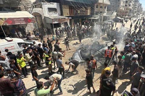 تجمّع فلسطينيون في موقع غارة إسرائيلية استهدفت مركبة مدنية في حي تل الهوى بمدينة غزة في 31 أغسطس/آب 2026، بينما يحاول رجال الإطفاء إخماد حريق اندلع في الموقع. وانتشلت فرق الإسعاف جثث ثلاثة فلسطينيين استشهدوا في الغارة. (صورة: هادي داود)