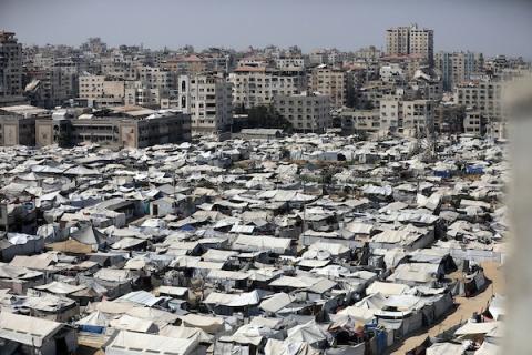 خيام تؤوي نازحين فلسطينيين على ساحل مدينة غزة وبين مبانٍ متضررة جراء الحرب، في 10 أغسطس/آب 2026. تصوير: بلال أسامة.