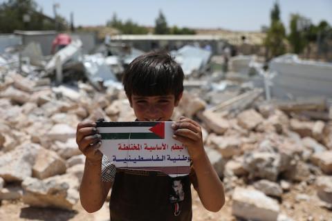 فلسطينيون يتفقدون أنقاض الجزء المهدوم من مدرسة شعب البطم الأساسية المختلطة جنوب الخليل، في مشهد يجسد التحديات التي تواجه حق الأطفال في التعليم. (تصوير: مأمون وزواز)