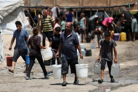 فلسطينيون نازحون يتجمعون للحصول على المياه في مخيم على شاطئ مدينة غزة، في 12 أغسطس/آب 2026. (صورة: أسامة)