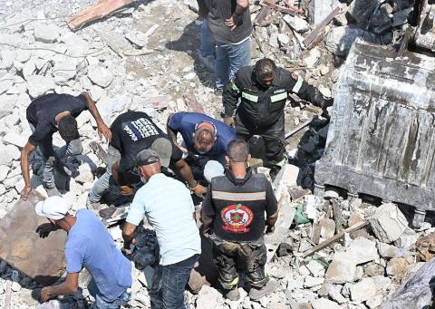 آليات ثقيلة ومسعفون يبحثون بين أنقاض الغارة الإسرائيلية على دير الزهراني (Getty Images).jpg